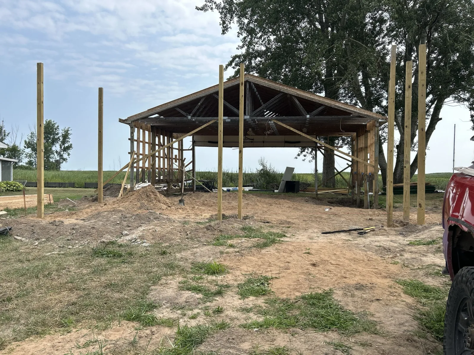 Our work: treated posts and the first trusses of a pole barn going up on open ground